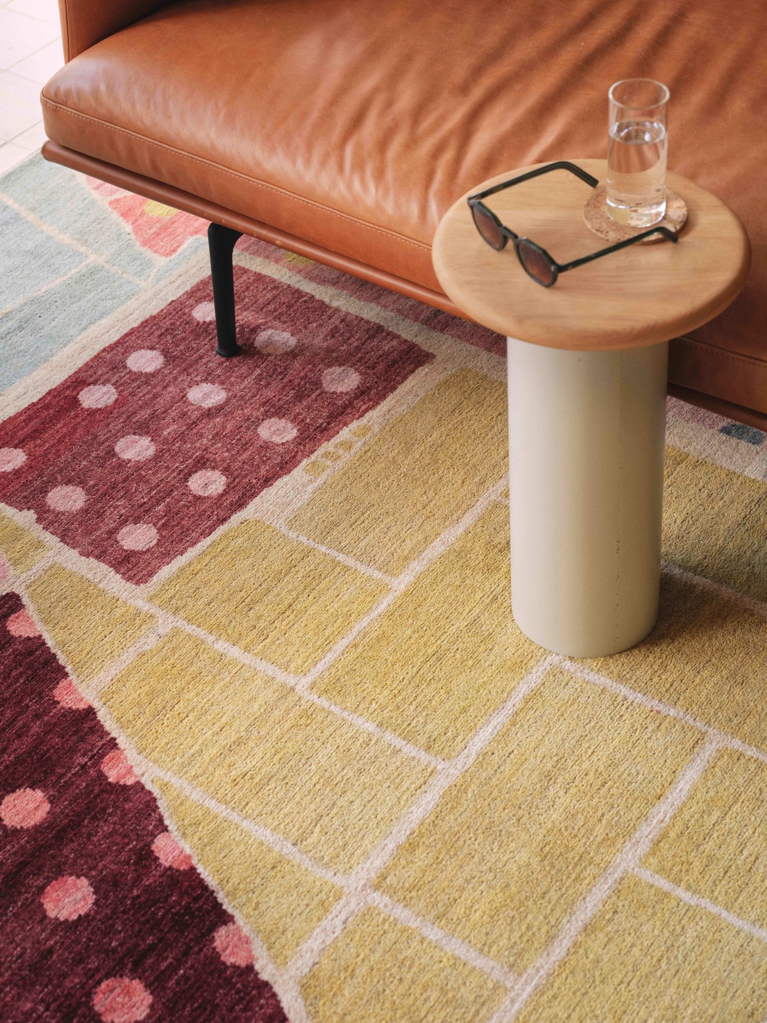 The textural Inset hand knotted rug from the Verso collection features layered brickwork and dotted squares in complimentary pink, green and blue tones.