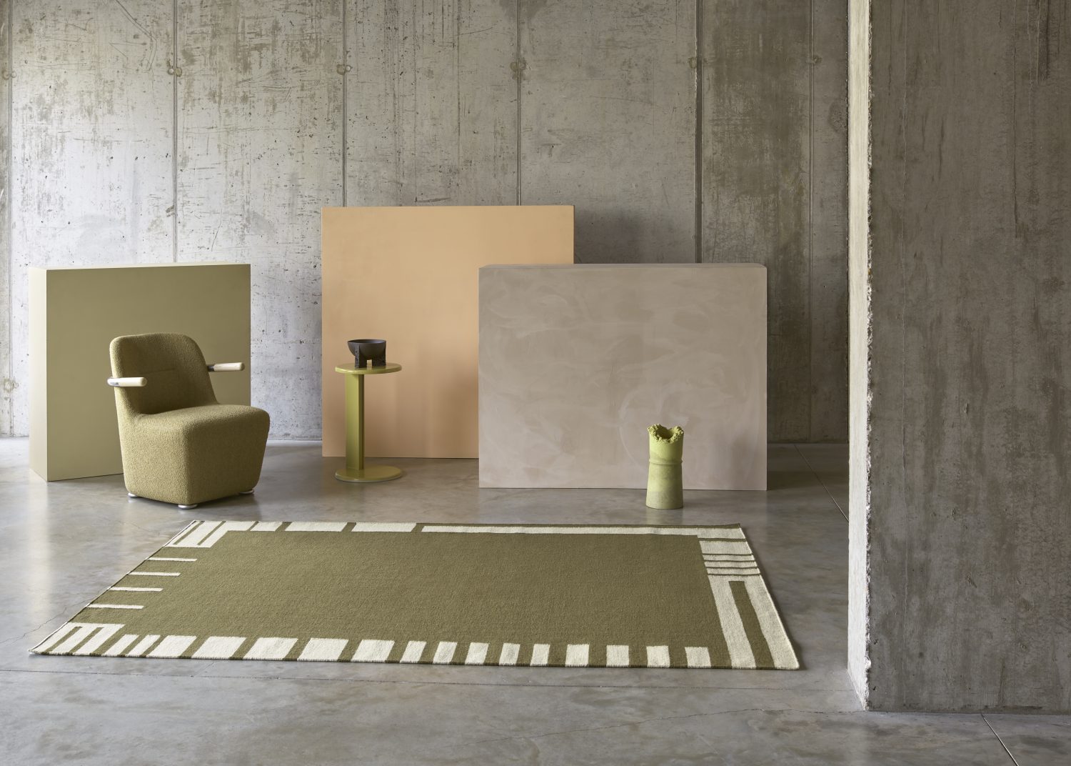 Irregular lines form a contemporary bordered rug in a contrasting olive coloured flatweave.